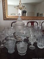 Assortment of crystal pieces on table, showing compote, goblets, tumblers, coupes, creamer, sugar