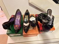 Three pairs of black heels displayed on boxes