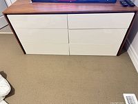 Front view showing six white gloss drawers framed by walnut veneer