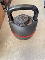 Full view of Bowflex adjustable kettlebell showing handle, body, and red accent band
