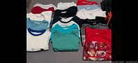 Overhead view of folded T-shirts in various colors and graphics
