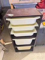 Front view showing four cream bins in dark brown laminate frame
