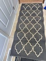 Full view of gray runner rug with ivory lattice pattern