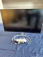 Front view of monitor on stand with power adapter and cord