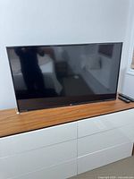 Front view of LG flat screen TV on cabinet