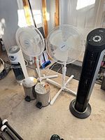 Full lot showing two pedestal fans, tower fan, humidifier, two trash cans