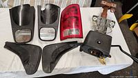 Group shot of all visible parts: two tow mirrors, tail light lens, steering column, two mud flap extensions