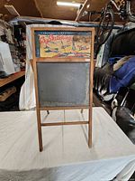 Full view of wooden child’s chalkboard easel standing on table