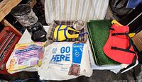 Group shot showing life jackets, dog bed, metal bowl, faux turf trays, automatic feeder, pee pad packs