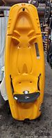 Front view of yellow kids kayak showing molded seat and hull