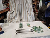 Entire lot showing glass vase partly filled with gems, three metal holders, loose gems, tealight pack