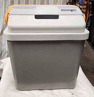 Front view of grey cooler with white lid and orange handle folded back