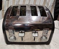 Front view showing four slots, brand logo, control panel with buttons and dials