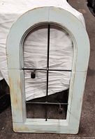 Front view showing arched wood frame, metal grid, two candle cups