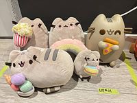 Group shot showing five plush Pusheen variants and vinyl figure