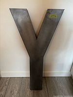 Front view of large metal letter Y showing brushed metal surface