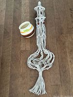 Full view macramé hanger beside pot