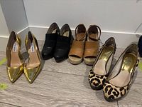 Four pairs of shoes lined up: gold pumps, black booties, tan wedges, leopard pumps