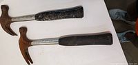 Both claw hammers on white surface showing overall condition