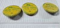 Three yellow Franklin County Crop Show buttons numbered 12, 36 and 50