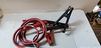 Jumper cable coiled with red wire, red and black clamps visible