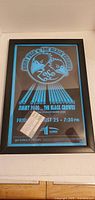 Framed concert poster with ticket stub visible