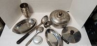 Overview of all stainless items: tumblers, platters, utensils, pot with lid, spare lid
