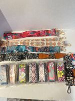 Overview of 14 woven straps laid out, showing variety of patterns and gold hardware