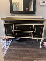 Front view of black and white Louis XVI-style buffet showing drawers, cabinet doors and hardware