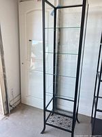 Full view of glass display cabinet showing metal frame and shelves