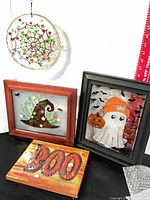 All four items grouped: suncatcher, two framed glass pieces, BOO plaque