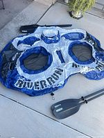 Deflated Intex River Run double raft with two Lifetime paddle shafts and blades