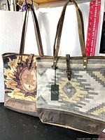 Two Myra Bag shoulder bags front view showing patterns, leather straps, tags