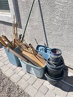 Overall lot showing two totes with wood pieces and stack of planters