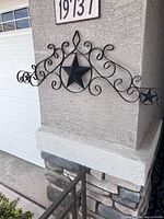 Full view of wrought iron scroll wall decor mounted on exterior wall