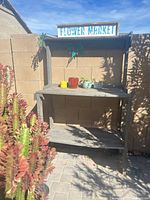 Front view of bench showing sign, pots, plants