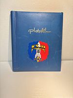 Front cover showing blue faux leather album with gold lettering and KSJO 92 FM sticker