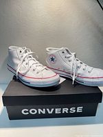 Pair of white Converse Chuck Taylor All Star Malden Street Mid high-top shoes on Converse box