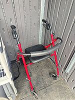 Full view of Guardian red rollator walker showing frame, wheels, seat and backrest