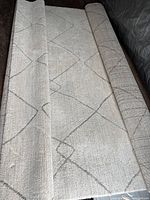 Rolled rug full view showing overall color and geometric pattern