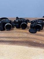 Front view of all three Fujifilm cameras on table