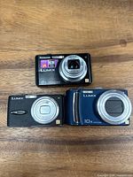 Front view of three Panasonic Lumix cameras showing lens and model markings