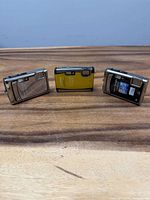 Front view of three Olympus Stylus Tough cameras showing finishes