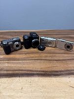 All four Kodak cameras on tabletop, lens cap visible