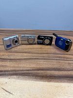 Front view of four compact digital cameras lined up