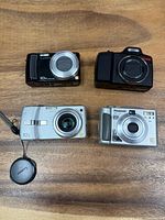 Front view of all four cameras showing brands, colors and lens details