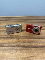 Front view of both Casio Exilim cameras showing colors, lens areas, branding