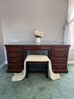 Front view showing desk drawers, glass top, bench