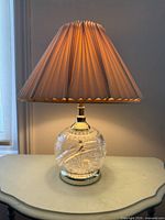 Lamp illuminated on side table showing whole form