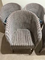 Front view of three chairs showing wicker weave and seat area